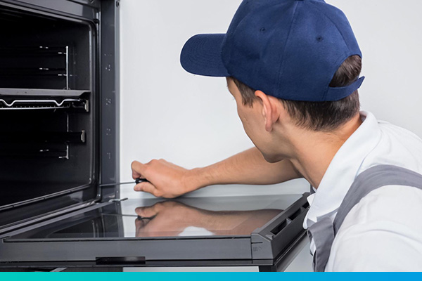 Techniker schraubt an einer Backofentür