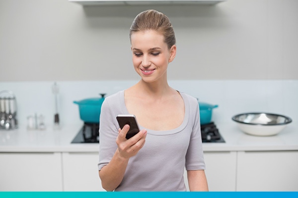 Frau in der Küche am Telefon