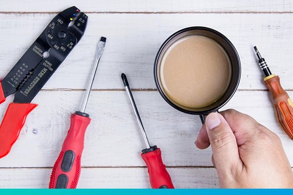 Werkzeuge und Kaffeetasse auf einer Tischplatte